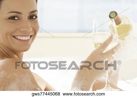 Portrait of a young woman pouring white wine into a wineglass View Large Photo Image Stock Photo - Portrait of a young woman pouring white wine into a wineglass. Fotosearch