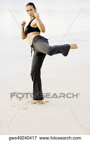 Portrait of a young woman practicing martial arts on the beach View Large Photo Image Stock Photo - Portrait of a young woman practicing martial arts on the beach. Fotosearch