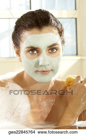 Portrait of a young woman scrubbing herself with a sponge View Large Photo Image Picture - Portrait of a young woman scrubbing herself with a sponge. Fotosearch