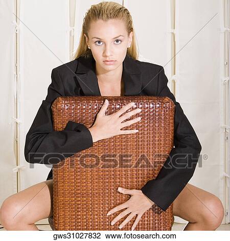 Portrait of a young woman sitting on a chair View Large Photo Image Stock Image - Portrait of a young woman sitting on a chair. Fotosearch