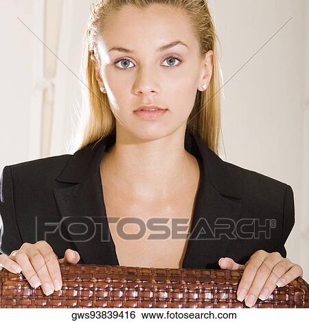 Portrait of a young woman sitting on a chair View Large Photo Image Stock Photograph - Portrait of a young woman sitting on a chair. Fotosearch