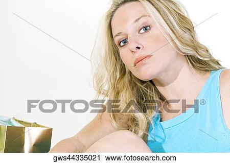 Portrait of a young woman sitting with a shopping bag View Large Photo Image Stock Image - Portrait of a young woman sitting with a shopping bag. Fotosearch