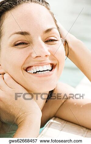 Portrait of a young woman smiling at the poolside View Large Photo Image Stock Photo - Portrait of a young woman smiling at the poolside. Fotosearch