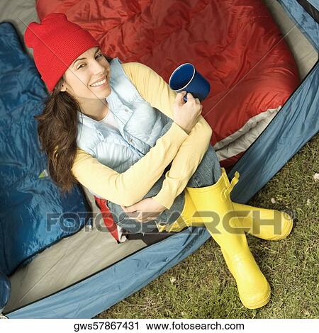 Portrait of a young woman smiling holding a cup View Large Photo Image Stock Image - Portrait of a young woman smiling holding a cup. Fotosearch