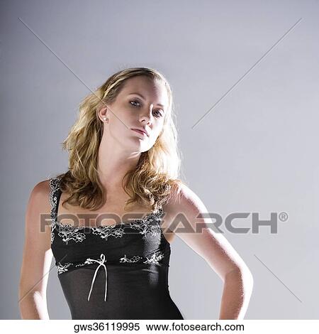 Portrait of a young woman standing with her hand on her hip View Large Photo Image Stock Photography - Portrait of a young woman standing with her hand on her hip. Fotosearch