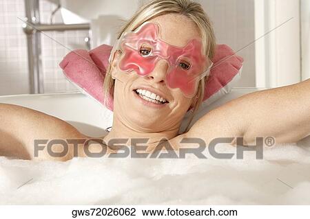 Portrait of a young woman wearing an eye mask in a bathtub View Large Photo Image Stock Image - Portrait of a young woman wearing an eye mask in a bathtub. Fotosearch