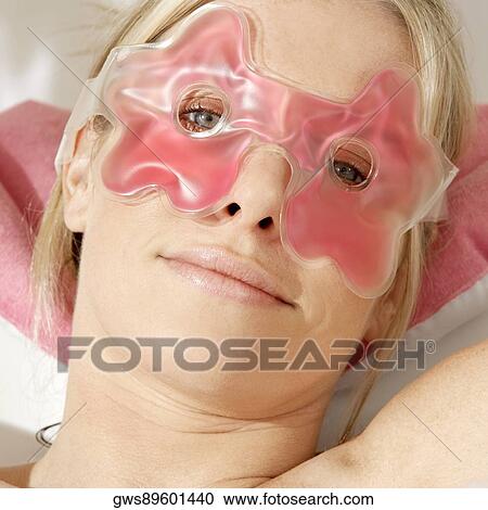 Stock Image - Portrait of a young woman wearing an eye mask. Fotosearch