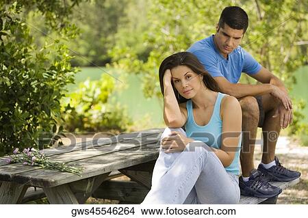 Portrait of a young woman with a mid adult man looking at her View Large Photo Image Picture - Portrait of a young woman with a mid adult man looking at her. Fotosearch