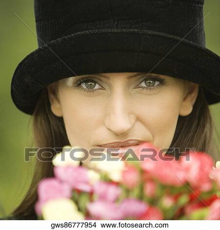 Portrait of a young woman with flowers in front of her View Large Photo Image Picture - Portrait of a young woman with flowers in front of her. Fotosearch