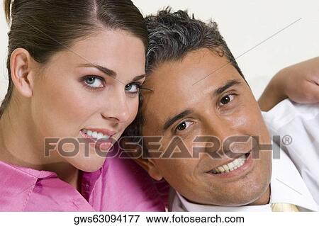 Portrait of a young woman with her arm around a mid adult man View Large Photo Image Stock Photo - Portrait of a young woman with her arm around a mid adult man. Fotosearch