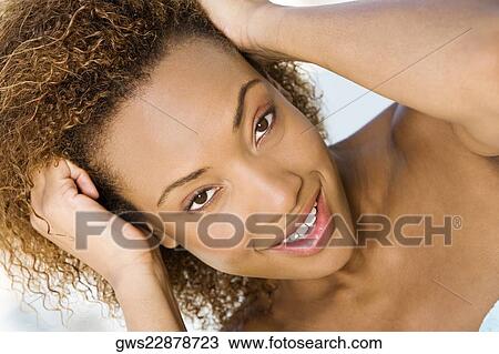 Portrait of a young woman with her hand in her hair View Large Photo Image Stock Image - Portrait of a young woman with her hand in her hair. Fotosearch