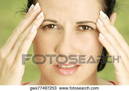 Portrait of a young woman with her hands on her head View Large Photo Image Stock Image - Portrait of a young woman with her hands on her head. Fotosearch