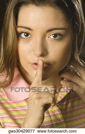 Portrait of a young woman with her finger on her lips View Large Photo Image Stock Photo - Portrait of a young woman with her finger on her lips. Fotosearch