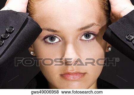 Portrait of a young woman with her hands on her head View Large Photo Image Stock Photo - Portrait of a young woman with her hands on her head. Fotosearch