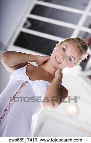 Portrait of a young woman with her hands behind her neck View Large Photo Image Stock Photo - Portrait of a young woman with her hands behind her neck. Fotosearch