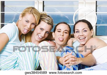 Stock Photo - Portrait of four young women sitting on a couch. Fotosearch