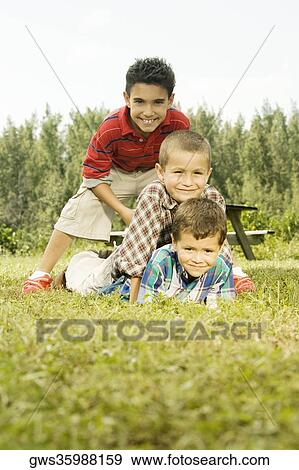Stock Photo - Portrait of three boys in the garden. Fotosearch