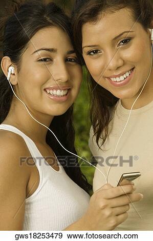 Portrait of two teenage girls holding an MP3 player listening to music View Large Photo Image Stock Photo - Portrait of two teenage girls holding an MP3 player listening to music. Fotosearch