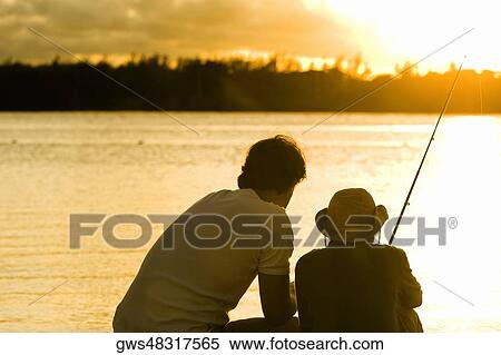 Rear view of a father and his son fishing View Large Photo Image Stock Photography - Rear view of a father and his son fishing. Fotosearch