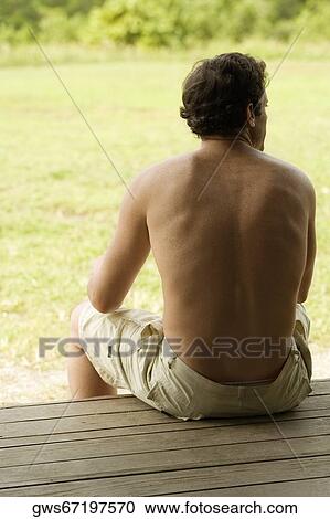 Rear view of a mid adult man sitting on a bench View Large Photo Image Stock Image - Rear view of a mid adult man sitting on a bench. Fotosearch