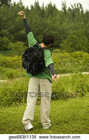 Rear view of a mid adult man standing with his arm outstretched View Large Photo Image Stock Photography - Rear view of a mid adult man standing with his arm outstretched. Fotosearch