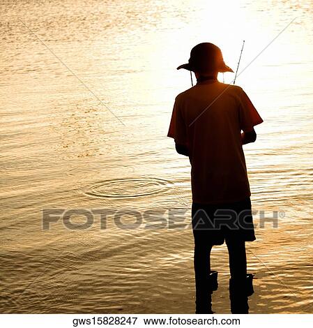 Rear view of a teenage boy fishing View Large Photo Image Stock Photo - Rear view of a teenage boy fishing. Fotosearch