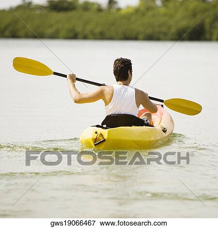 Rear view of a young man kayaking in a lake View Large Photo Image Stock Photo - Rear view of a young man kayaking in a lake. Fotosearch