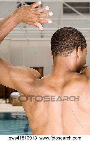 Rear view of a young man standing at the poolside View Large Photo Image Stock Image - Rear view of a young man standing at the poolside. Fotosearch