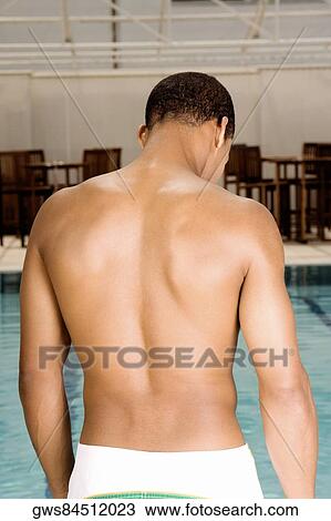 Rear view of a young man standing at the poolside View Large Photo Image Stock Image - Rear view of a young man standing at the poolside. Fotosearch
