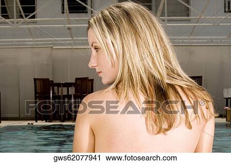 Stock Image - Rear view of a young woman looking sideways. Fotosearch