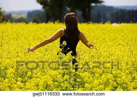 Rear view of a young woman standing in a field, Czech Republic View Large Photo Image Stock Image - Rear view of a young woman standing in a field, Czech Republic. Fotosearch