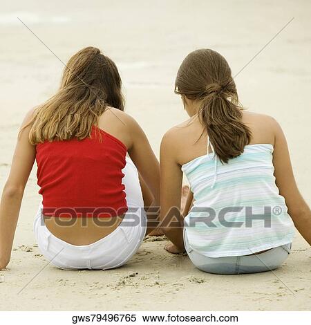 Rear view of girl and a teenage girl sitting together on the beach View Large Photo Image Stock Photography - Rear view of girl and a teenage girl sitting together on the beach. Fotosearch