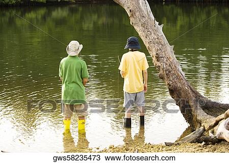 Rear view of two boys fishing in a lake View Large Photo Image Stock Image - Rear view of two boys fishing in a lake. Fotosearch