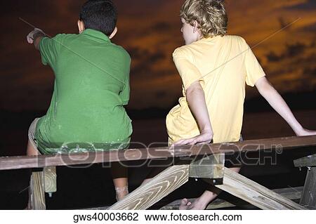 Rear view of two boys sitting on a picnic table View Large Photo Image Stock Image - Rear view of two boys sitting on a picnic table. Fotosearch