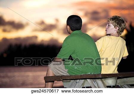 Rear view of two boys sitting on a picnic table View Large Photo Image Stock Photo - Rear view of two boys sitting on a picnic table. Fotosearch