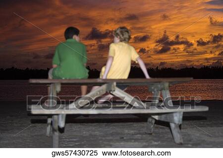 Rear view of two boys sitting on a picnic table View Large Photo Image Stock Photography - Rear view of two boys sitting on a picnic table. Fotosearch