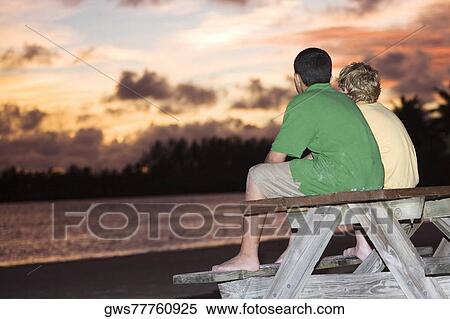 Stock Photography - Rear view of two boys sitting on a picnic table. Fotosearch