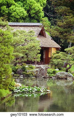 Stock Image - Reflection of a house and trees in a lake, Katsura Imperial Garden, Kyoto, Japan. Fotosearch