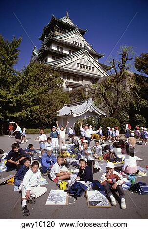 Stock Image - School children in front of a castle, Osaka Castle, Osaka, Japan. Fotosearch