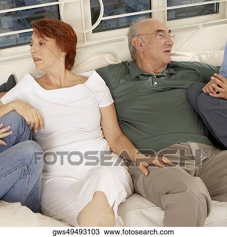 Stock Image - Senior couple sitting together on a couch. Fotosearch