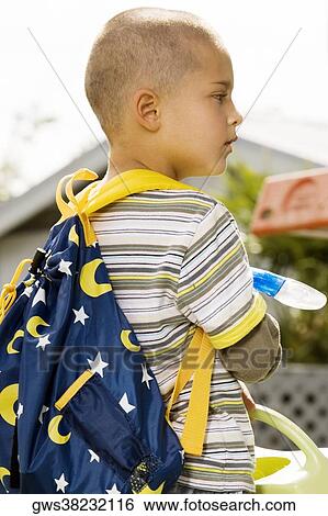 Side profile of a boy carrying a backpack View Large Photo Image Stock Photograph - Side profile of a boy carrying a backpack. Fotosearch