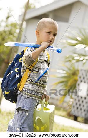Stock Photography - Side profile of a boy holding a watering can and snorkel. Fotosearch
