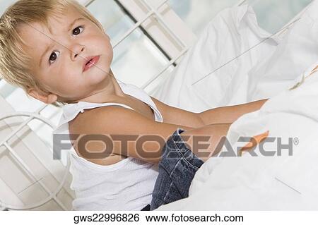Side profile of a boy sitting on the bed View Large Photo Image Stock Photograph - Side profile of a boy sitting on the bed. Fotosearch