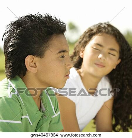 Side profile of a brother and his sister sitting together View Large Photo Image Picture - Side profile of a brother and his sister sitting together. Fotosearch