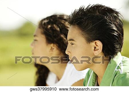 Side profile of a brother and his sister sitting together View Large Photo Image Stock Image - Side profile of a brother and his sister sitting together. Fotosearch