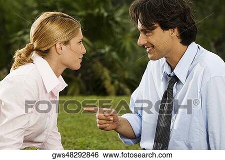 Stock Photograph - Side profile of a businessman and a businesswoman looking at each other. Fotosearch