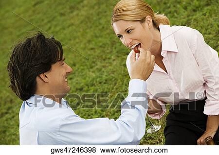 Side profile of a businessman feeding a cherry to a businesswoman View Large Photo Image Stock Photo - Side profile of a businessman feeding a cherry to a businesswoman. Fotosearch