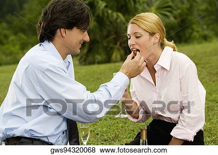 Side profile of a businessman feeding a cherry to a businesswoman View Large Photo Image Stock Photo - Side profile of a businessman feeding a cherry to a businesswoman. Fotosearch