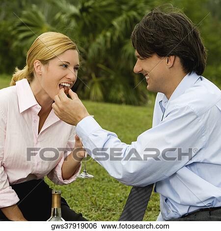 Side profile of a businessman feeding a cherry to a businesswoman View Large Photo Image Stock Photograph - Side profile of a businessman feeding a cherry to a businesswoman. Fotosearch