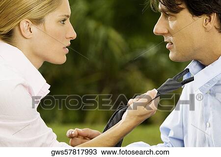 Side profile of a businesswoman holding a businessman's tie View Large Photo Image Stock Image - Side profile of a businesswoman holding a businessman's tie. Fotosearch